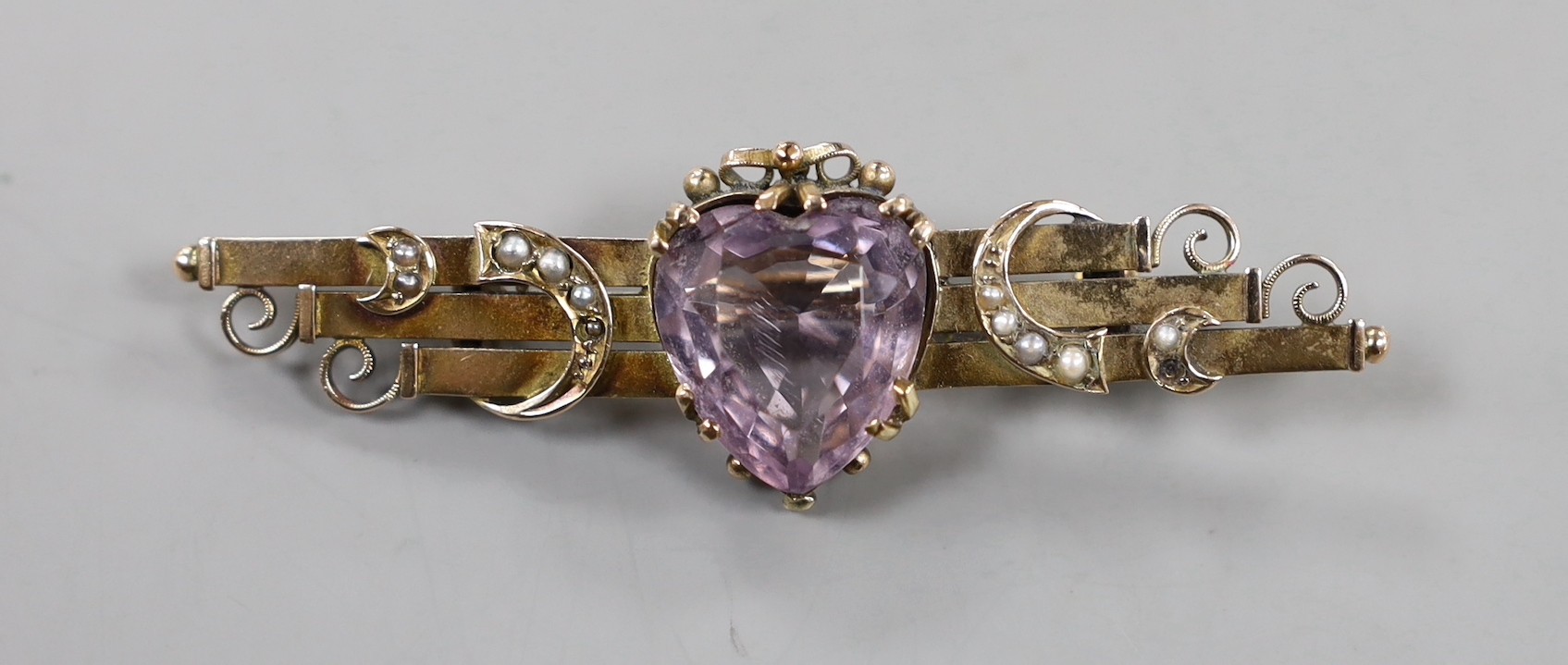An early 20th century 9ct gold, heart shaped amethyst and seed pearl set bar brooch, 59mm, gross weight 5.7 grams.